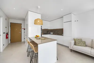 a kitchen and living room with a counter and a couch at Terraços de Quarteira Ethnic by Real Properties in Quarteira
