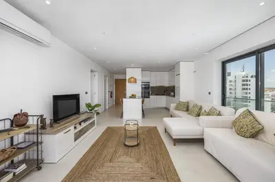 a living room with white furniture and a large window at Terraços de Quarteira Ethnic by Real Properties in Quarteira
