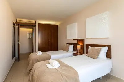 a hotel room with two beds with towels on them at TAC - Salgados Beach Prime Pool Resort in Guia
