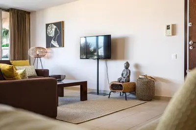 a living room with a couch and a tv at TAC - Salgados Beach Prime Pool Resort in Guia