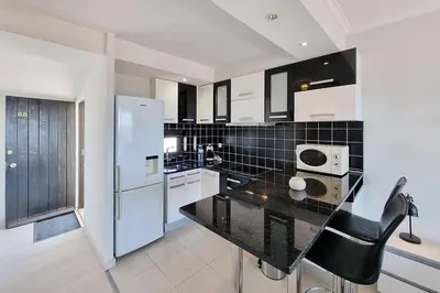 a kitchen with a black counter top and white appliances at Blue Sea in Albufeira