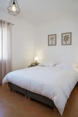 a bedroom with a large white bed with a lamp at Jardins da Galé Beach House in Albufeira