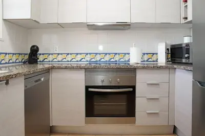 a kitchen with a stove top oven in a kitchen at Jardins da Galé Beach House in Albufeira