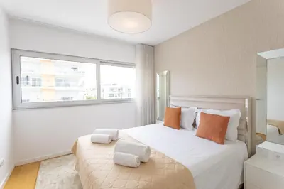 a bedroom with a large bed with orange and white pillows at Glamour Apartment With Pool in Albufeira