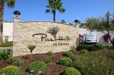 a sign for a hotel in a garden at Vilamoura Pine Hills Luxury Apartment in Quarteira