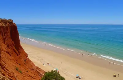 a group of people on a beach near the ocean at Vilamoura Pine Hills Luxury Apartment in Quarteira
