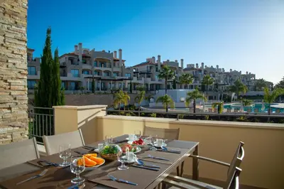 a table on a balcony with a view of buildings at Vilamoura Pine Hills Luxury Apartment in Quarteira