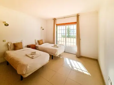 two beds in a room with a window at FLH Quinta das Salinas Triplex with Balcony in Vale do Lobo