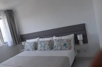 a bedroom with a white bed with pillows at Varanda para o Mar in Albufeira