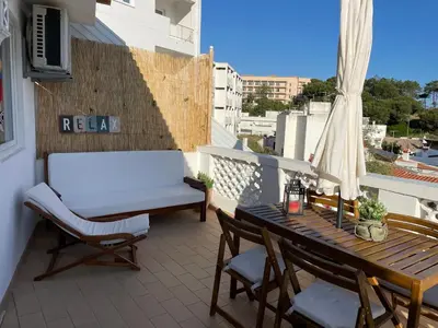 a balcony with a table and chairs and a bench at Varanda para o Mar in Albufeira