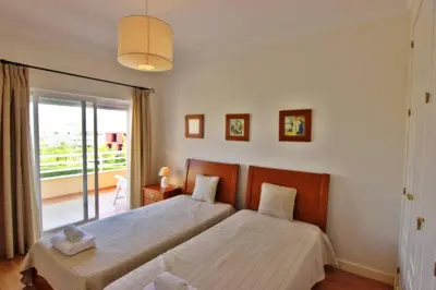 a bedroom with two beds and a balcony at ViaMar Apartment in Vilamoura