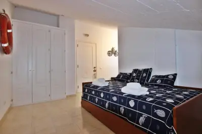 a bedroom with a large bed with black and white sheets at ViaMar Apartment in Vilamoura