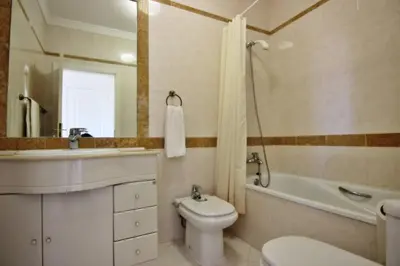 a bathroom with a toilet and a sink and a tub at ViaMar Apartment in Vilamoura