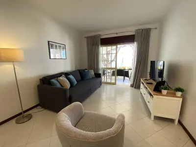 a living room with a couch and a chair at Vilamoura Garden View 2 With Pool by Homing in Vilamoura