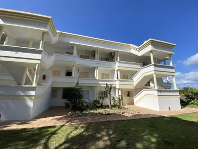 a large white apartment building with a yard at Vilamoura Garden View 2 With Pool by Homing in Vilamoura