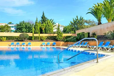 a swimming pool with blue chairs and a swimming pool at FLH Albufeira Ocean View House with Garden & Pool in Albufeira