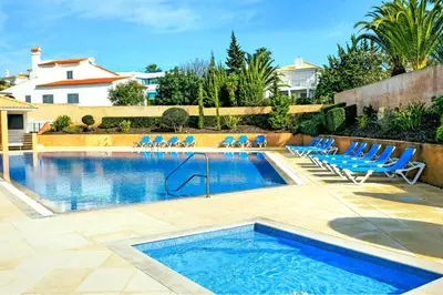 a swimming pool with blue chairs and a swimming pool at FLH Albufeira Ocean View House with Garden & Pool in Albufeira