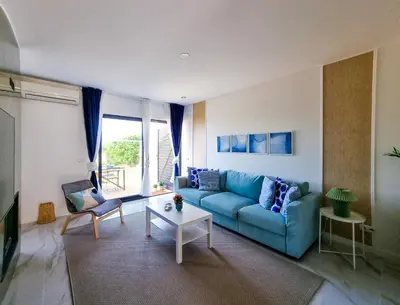a living room with a blue couch and a table at FLH Albufeira Ocean View House with Garden & Pool in Albufeira