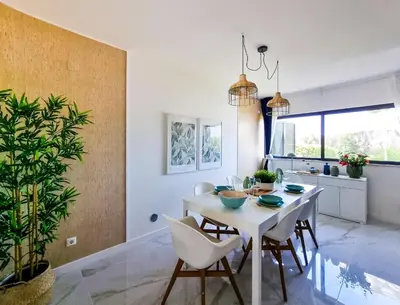 a kitchen and dining room with a white table and chairs at FLH Albufeira Ocean View House with Garden & Pool in Albufeira
