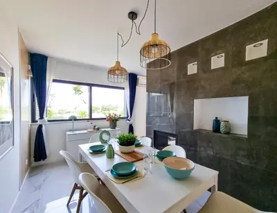 a dining room with a white table and chairs at FLH Albufeira Ocean View House with Garden & Pool in Albufeira