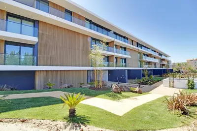 an apartment building with a garden in front of it at White & Nature Apartment in Vilamoura