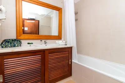 a bathroom with a sink and a mirror and a tub at Apartamento do Pinhal - By Dalma Portuguesa in Albufeira