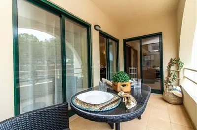 a table with plates and a plant and a glass at Apartamento do Pinhal - By Dalma Portuguesa in Albufeira