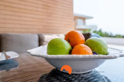 a bowl of oranges and limes on a table at #160 V3 Vila Branca 92 by Home Holidays in Albufeira