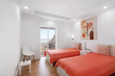 a hotel room with two beds and a window at Moderno e renovado T2 in Quarteira