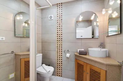 a bathroom with a toilet and a sink and mirror at Moderno e renovado T2 in Quarteira
