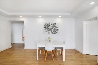 a white dining room with a white table and chairs at Moderno e renovado T2 in Quarteira