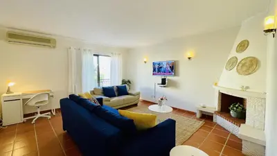 a living room with a blue couch and a fireplace at Neridas Villa by Check-in Portugal in Quarteira