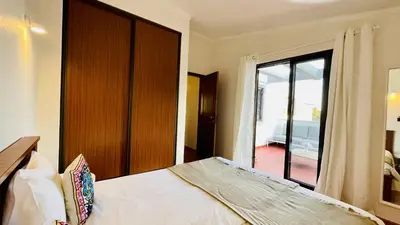 a bedroom with a bed and a sliding glass door at Neridas Villa by Check-in Portugal in Quarteira