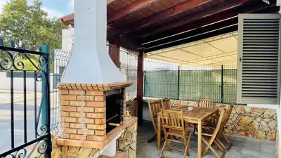 a patio with a fireplace and a table and chairs at Neridas Villa by Check-in Portugal in Quarteira