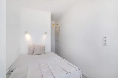 a small white room with a bed in it at Lindo T2 com vista mar in Quarteira