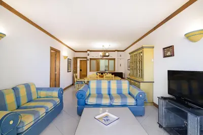 a living room with two blue couches and a television at T2 com piscina centro Vilamoura in Vilamoura