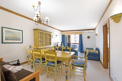 a dining room with a yellow table and chairs at T2 com piscina centro Vilamoura in Vilamoura
