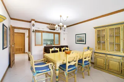 a dining room with a wooden table and chairs at T2 com piscina centro Vilamoura in Vilamoura