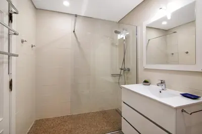 a white bathroom with a shower and a sink at T2 com piscina centro Vilamoura in Vilamoura