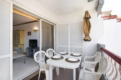 a white dining room with a white table and chairs at T2 com piscina centro Vilamoura in Vilamoura