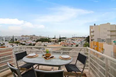 a balcony with a table and chairs and a view of a city at Vilamoura Marina in Vilamoura