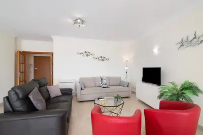 a living room with a couch and red chairs at Vilamoura Marina in Vilamoura
