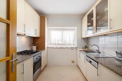 a kitchen with white cabinets and a window at Vilamoura Marina in Vilamoura
