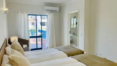a white bedroom with a bed and a window at Jardim da Oura by Check-in Portugal in Albufeira