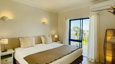 a bedroom with a bed and a large window at Jardim da Oura by Check-in Portugal in Albufeira