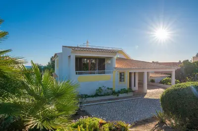 a white house with the sun in the sky at Villa Andrea by Gabi Miguel in Albufeira