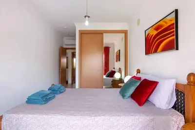 a bedroom with a bed with red and blue pillows at T2 Encosta São José by Gabi Miguel in Guia