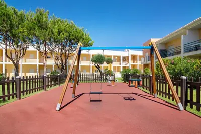 a swing set in a playground in a building at T2 Encosta São José by Gabi Miguel in Guia