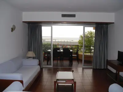 a living room with a couch and a dining room at Aparthotel Dom Pedro Portobelo in Vilamoura