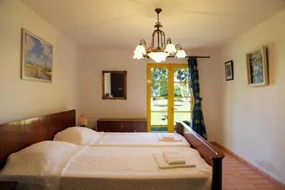 a bedroom with a bed with a chandelier and a window at Sunset Pôr do sol in Galé